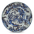 Delft. grand plat rond en faïence à décor en camaïeu bleu et manganèse de chinois dans le jardin d'un palais, xviième siècle 