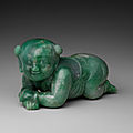 A rare large green and russet jade 'boy' brush rest, 17th century