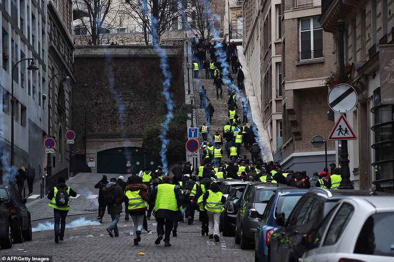 7934524-6537891-Protesters_walk_up_stairs_as_tear_gas_is_fired_near_the_Passy_ar-a-66_1546106506642