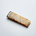 A white and russet jade 'cloud scroll' scabbard slide, warring states period (475-221 bc)