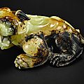 A superbly carved russet jade figure of a recumbent mythical beast, ming dynasty or earlier
