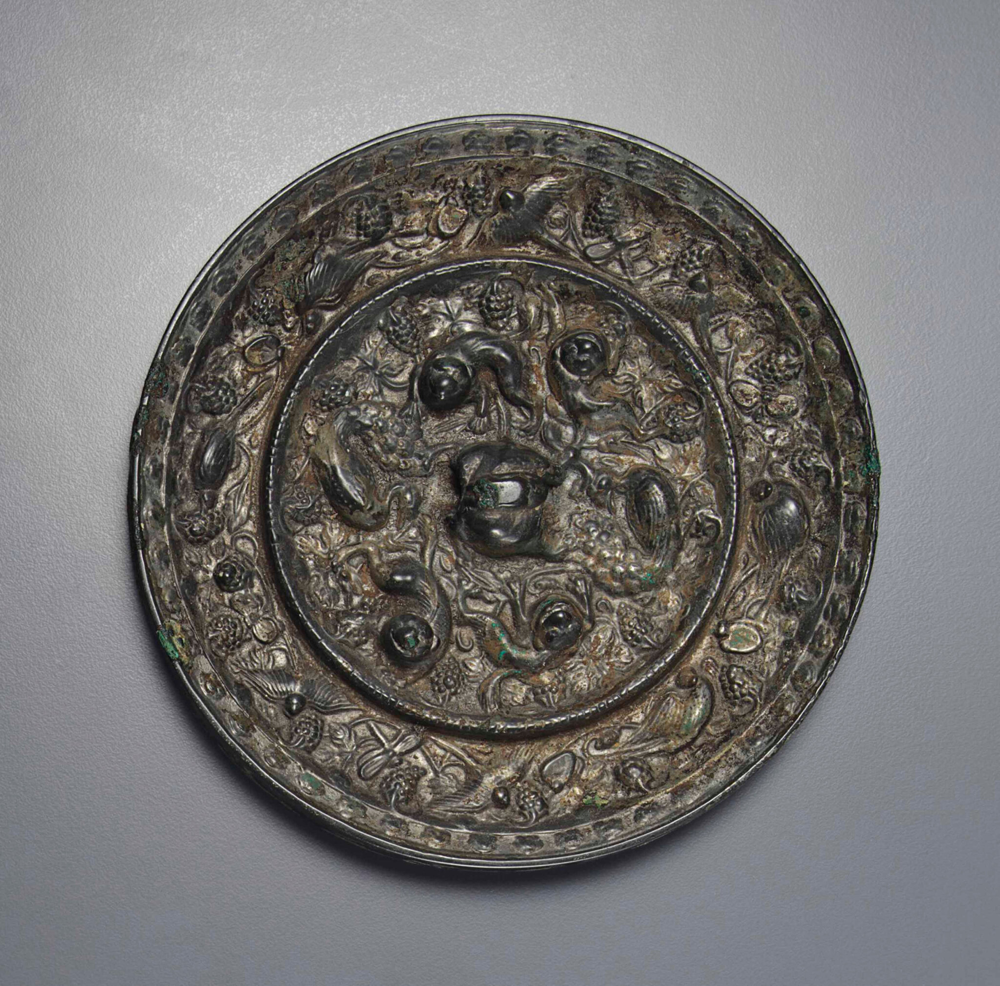 A bronze 'Lion and grapevine' circular mirror, Tang dynasty (AD 618-907)