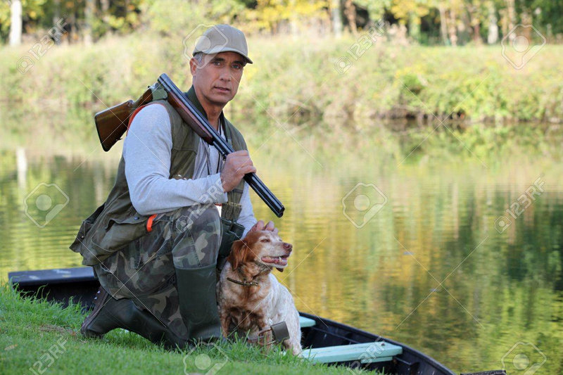 un-chasseur-et-son-chien-par-une-rivière-