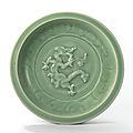A rare carved and moulded ‘dragon’ charger, Yuan dynasty (1279-1368)