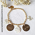 Bracelet personnalisé sur chaîne plaqué or maille classique composé de 2 colombes en nacre, 2 médailles en plaqué or gravées à la machine et une médaille de Vierge à l'Enfant en nacre (détails)