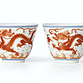 A fine pair of small iron-red decorated 'dragon' cups, seal marks and period of qianlong