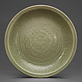 A large carved longquan celadon charger, ming dynasty, 15th century